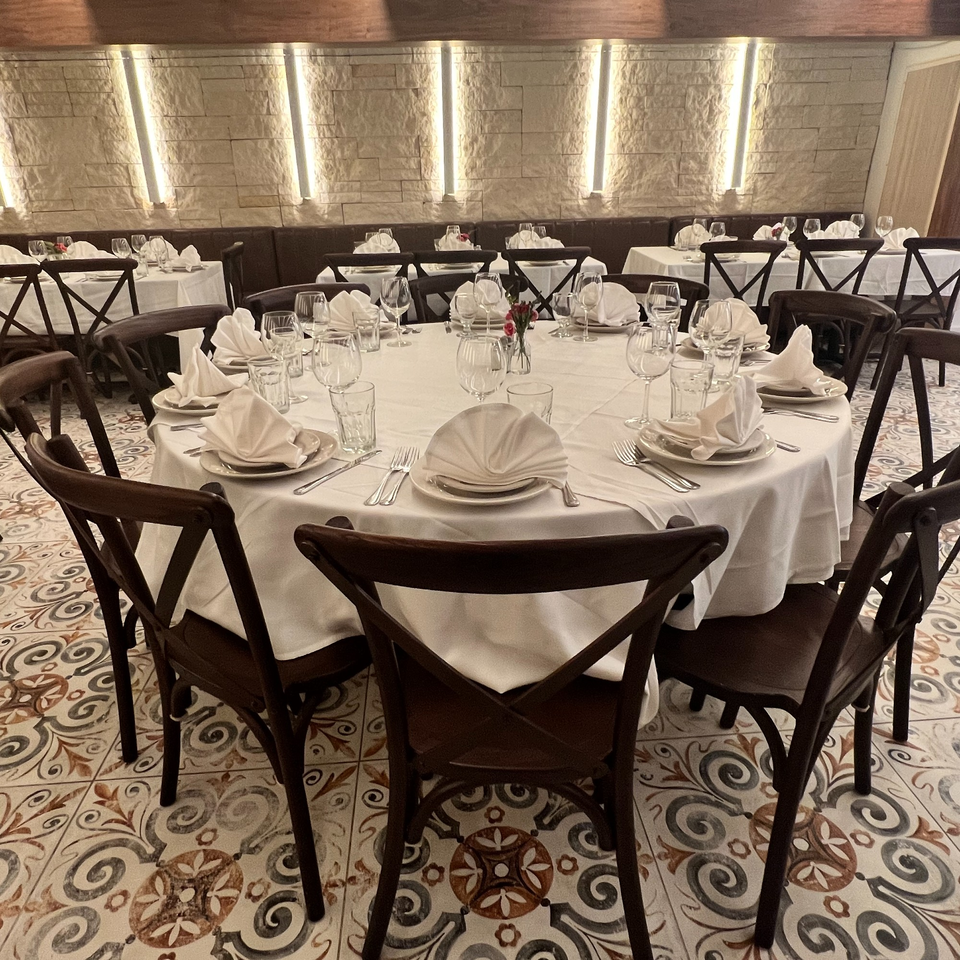 Alba's Pizzeria & Restaurant dining room with set tables, dark chairs, and patterned floor tiles.
