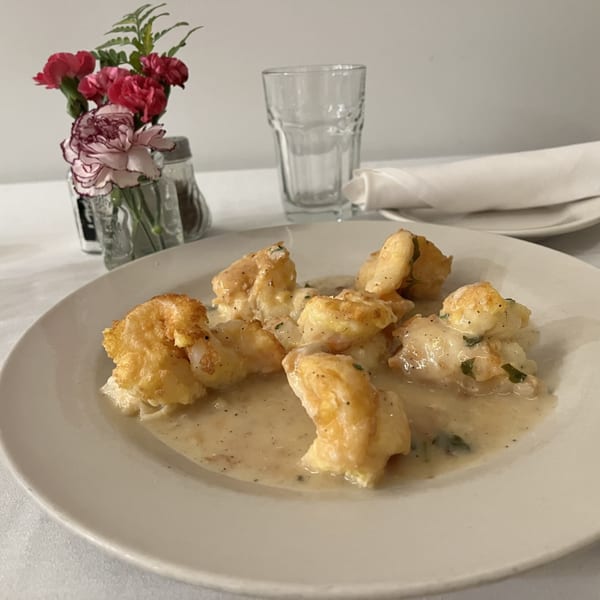 Alba's Pizzeria & Restaurant's fried shrimp in a creamy sauce, with flowers and a glass.