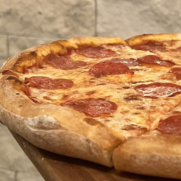 Close-up of a freshly baked pepperoni pizza from Alba's Pizzeria, with a golden crust and melted cheese.